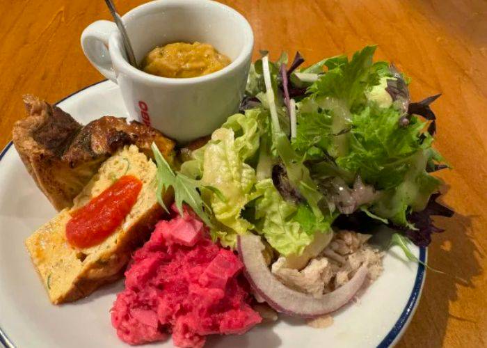 A mixed salad platter at Deli a Casa, showing a variety of fresh colors and textures.